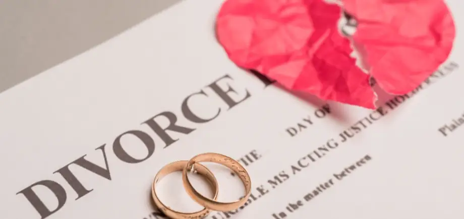 Marriage rings resting over divorce papers