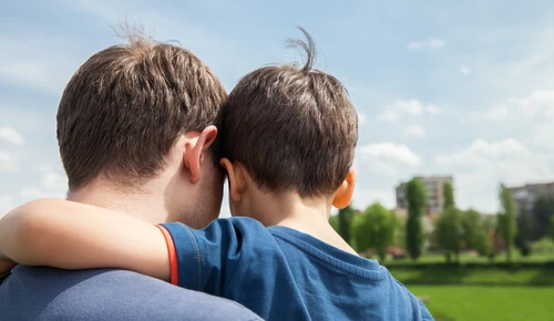 Father and son on a city background. View from the back